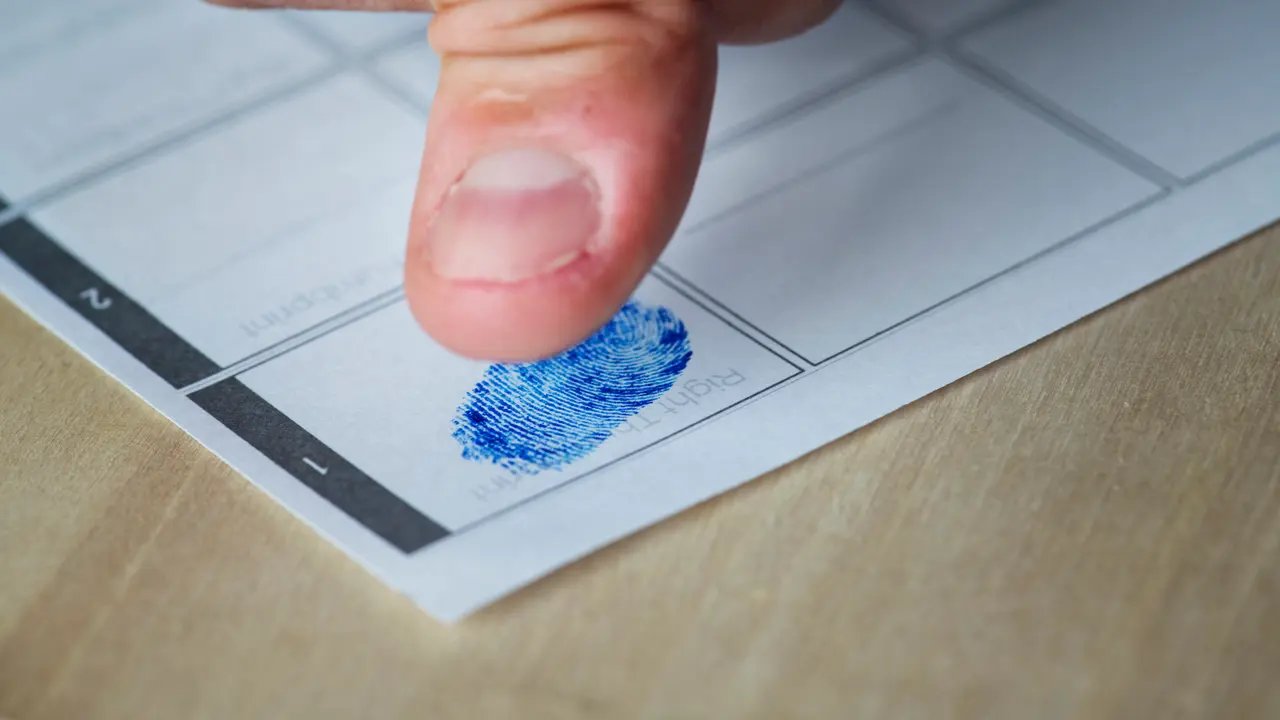 Voter pressing an inked thumbprint onto a ballot paper
